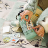 Parks Project Peanuts x Parks Project Recycled Water Bottle and Sticker Pack in hand